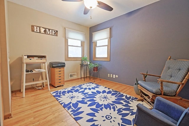 sitting room with hardwood / wood-style flooring and ceiling fan