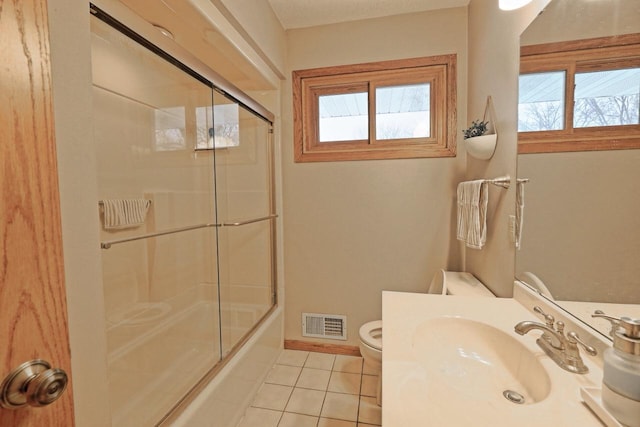 full bathroom featuring enclosed tub / shower combo, tile patterned floors, toilet, and sink