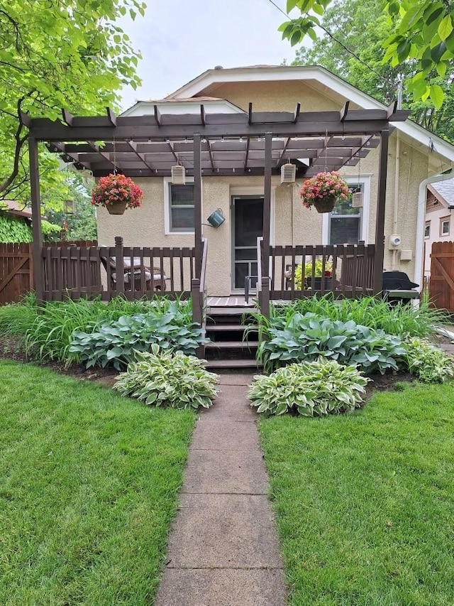 view of front of property featuring a wooden deck, a pergola, and a front yard