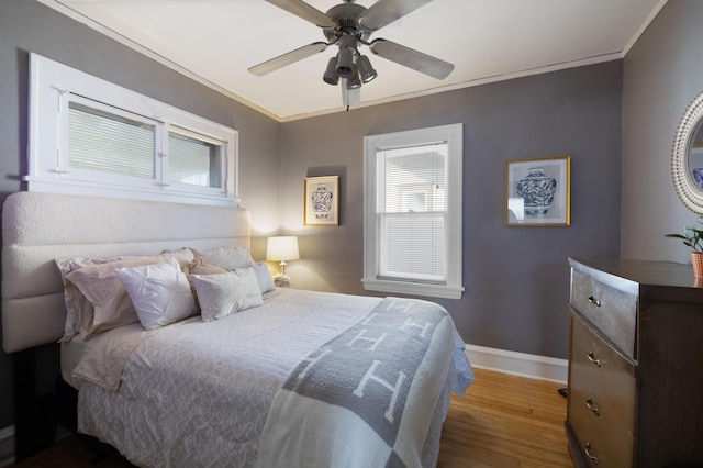 bedroom with multiple windows, ornamental molding, and hardwood / wood-style floors