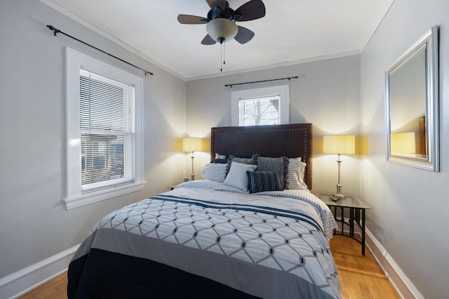 bedroom with ceiling fan, ornamental molding, and wood-type flooring