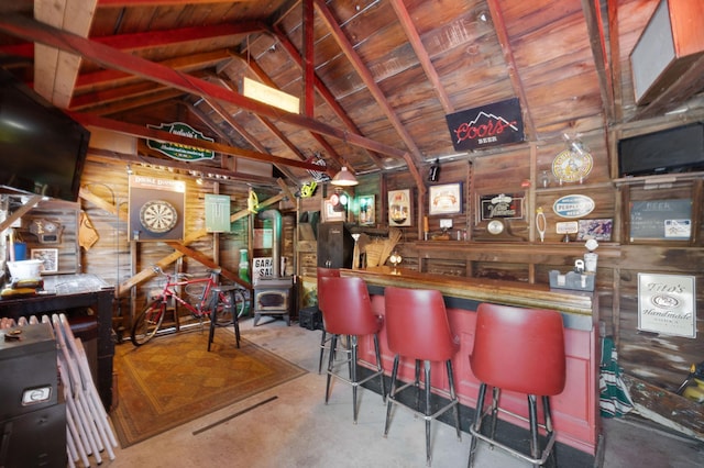 bar with lofted ceiling, wooden walls, concrete floors, and a wood stove