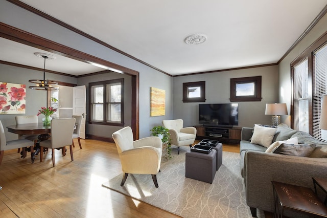 living room with ornamental molding and light hardwood / wood-style flooring