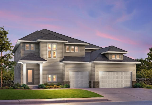 view of front of home with a garage and a lawn