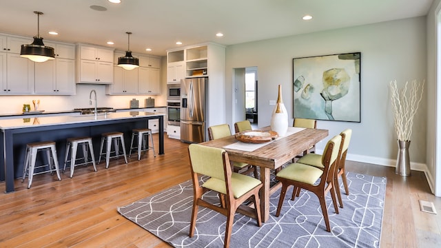 dining room with sink and light hardwood / wood-style floors