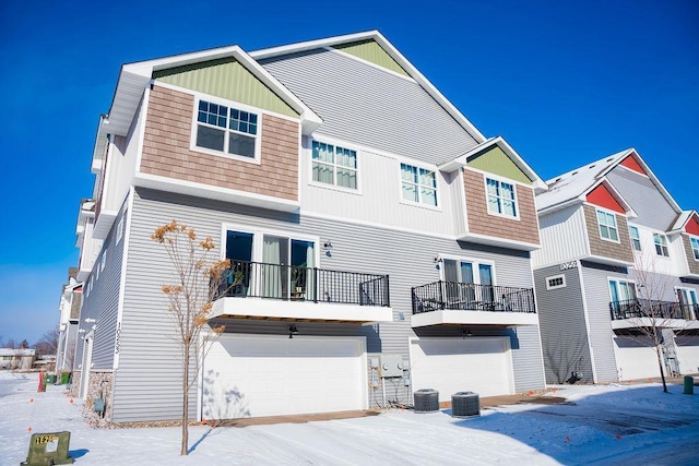 snow covered rear of property with a balcony and central air condition unit