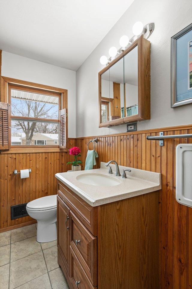 bathroom with tile patterned floors, vanity, toilet, and wood walls