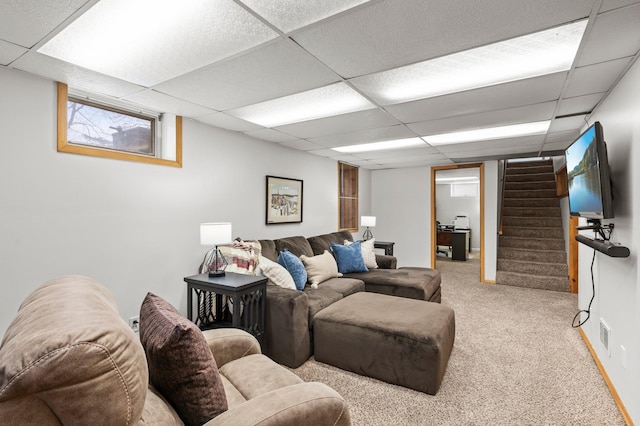 carpeted living room with a drop ceiling