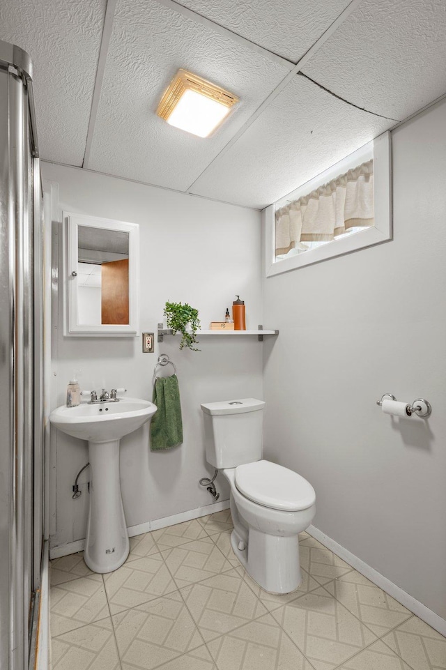 bathroom featuring sink, a paneled ceiling, and toilet