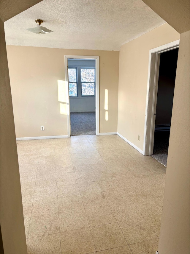 unfurnished room featuring a textured ceiling