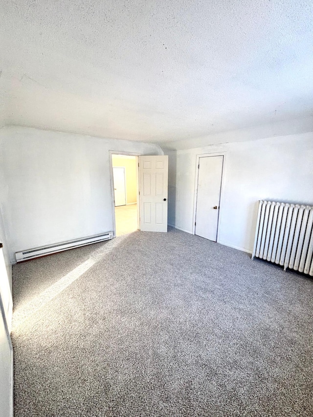 unfurnished room featuring a baseboard radiator, carpet floors, radiator heating unit, and a textured ceiling