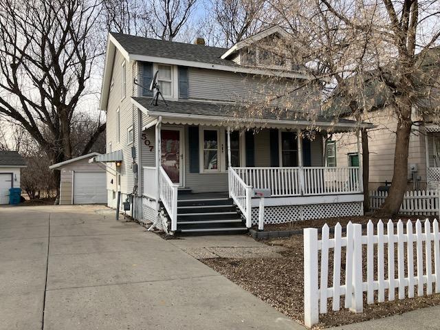 view of front of property featuring a porch, a garage, and an outdoor structure