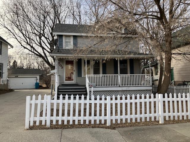 view of front facade featuring an outbuilding, a garage, and covered porch