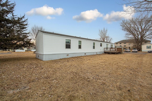 back of house with a wooden deck and a yard