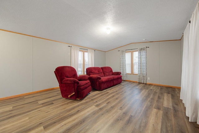 living room featuring hardwood / wood-style flooring, vaulted ceiling, crown molding, and a textured ceiling