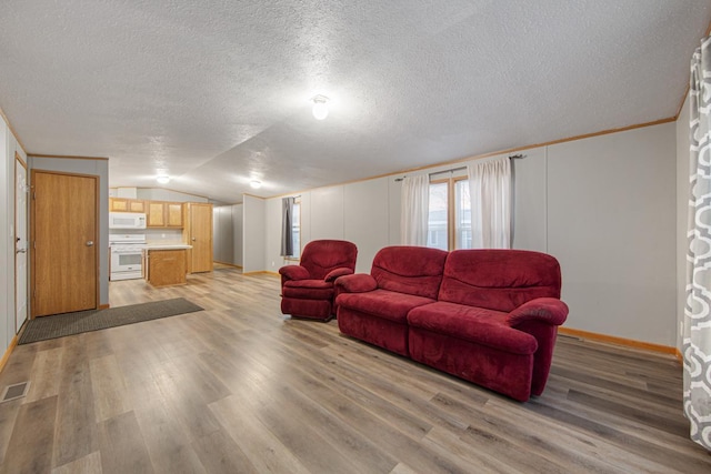 living room featuring crown molding, vaulted ceiling, a textured ceiling, and light wood-type flooring