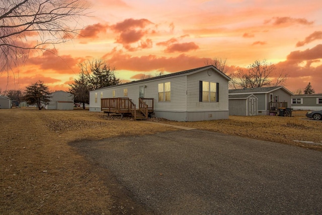 view of front of home featuring a storage unit and a deck