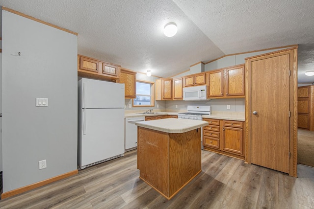 kitchen featuring wood-type flooring, lofted ceiling, a center island, and white appliances