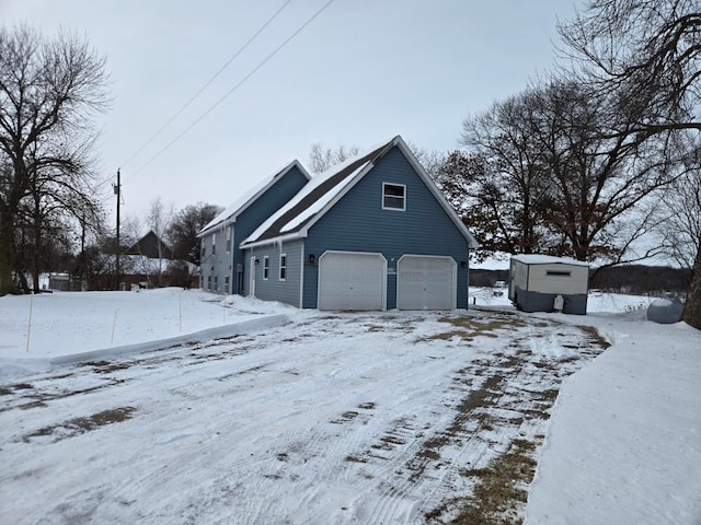 view of snowy exterior featuring a garage