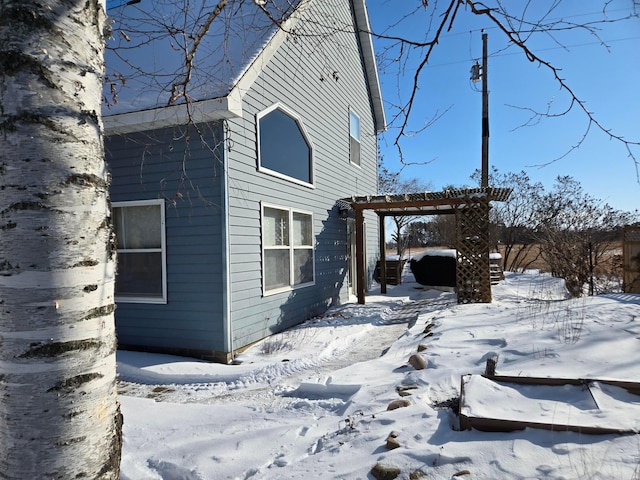 view of snow covered exterior with a pergola