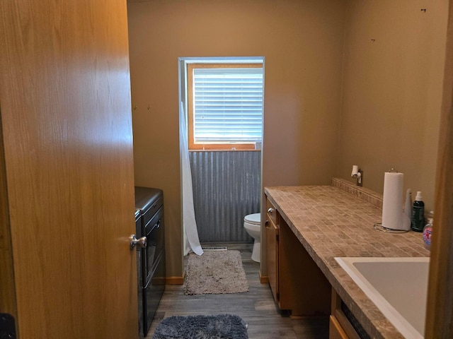 bathroom with hardwood / wood-style flooring, vanity, and toilet