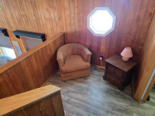 sitting room featuring hardwood / wood-style flooring and wood walls