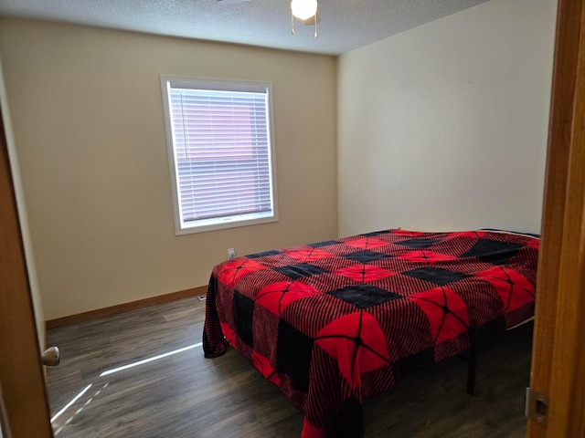 bedroom with a textured ceiling and dark wood-type flooring