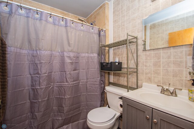 bathroom with tasteful backsplash, tile walls, vanity, toilet, and a shower with curtain