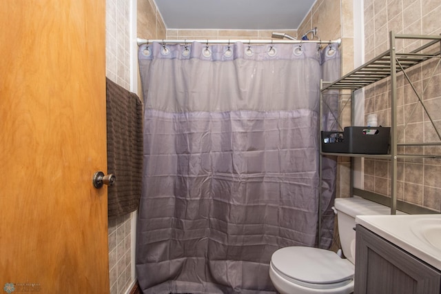 bathroom with a shower with curtain, vanity, toilet, and tile walls