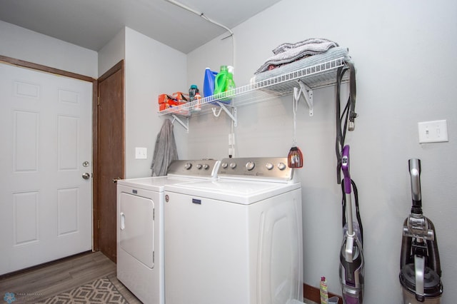 laundry area featuring wood-type flooring and separate washer and dryer