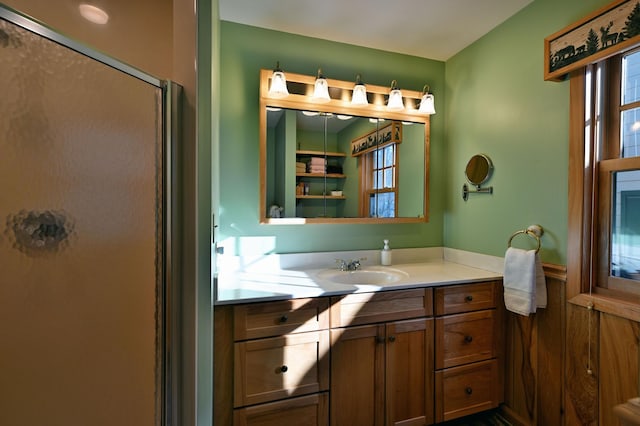 bathroom with vanity and a shower with door