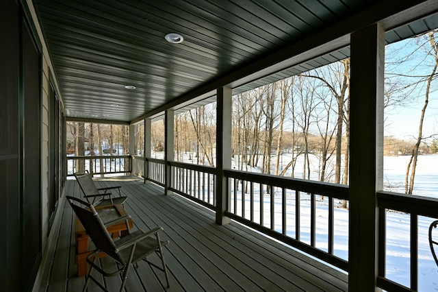 snow covered deck featuring a water view