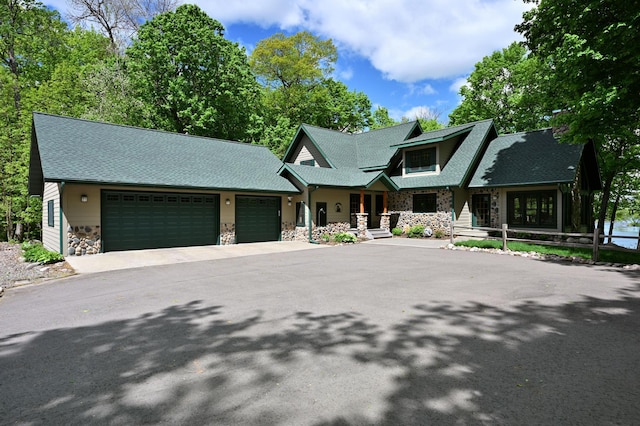 2772 25th Ave Unit B, Cedar Lake Twp, WI 54868 - view of front of house featuring stone siding, a garage, driveway, and a shingled roof