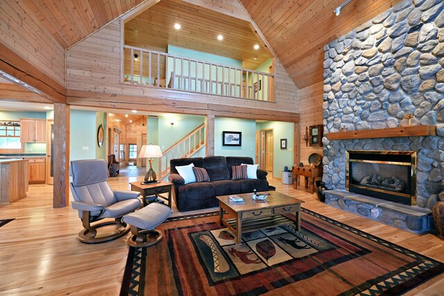 2772 25th Ave Unit B, Cedar Lake Twp, WI 54868 - living area featuring high vaulted ceiling, stairs, light wood-style floors, wooden ceiling, and a stone fireplace