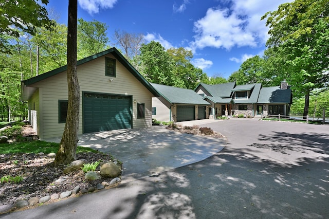 2772 25th Ave Unit B, Cedar Lake Twp, WI 54868 - view of front facade featuring a chimney, stone siding, and a detached garage