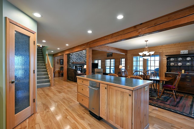 2772 25th Ave Unit B, Cedar Lake Twp, WI 54868 - kitchen featuring wood walls, dark countertops, light brown cabinetry, a stone fireplace, and light wood-style flooring