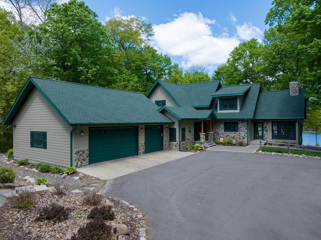 2772 25th Ave Unit B, Cedar Lake Twp, WI 54868 - view of front of property with stone siding, a chimney, asphalt driveway, an attached garage, and a porch