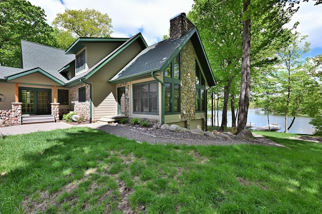 2772 25th Ave Unit B, Cedar Lake Twp, WI 54868 - back of property with stone siding, a chimney, a water view, and a yard