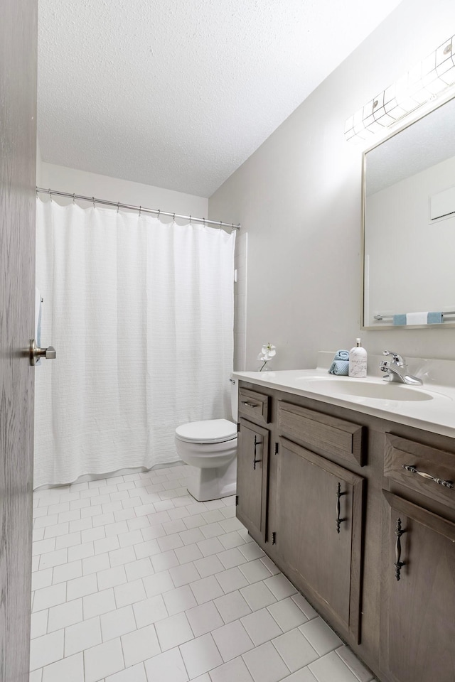 full bath with toilet, curtained shower, a textured ceiling, and vanity