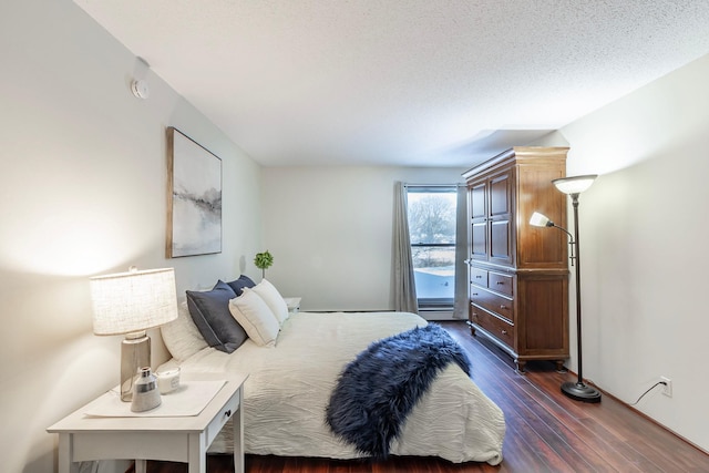 bedroom featuring dark wood-style flooring and a textured ceiling