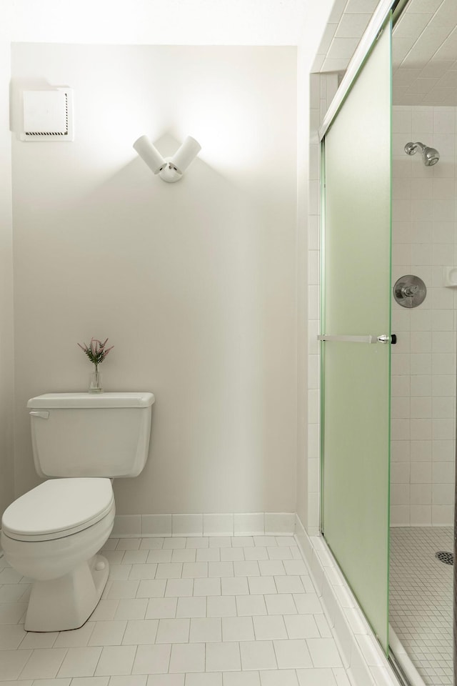 full bathroom with a stall shower, toilet, and tile patterned floors