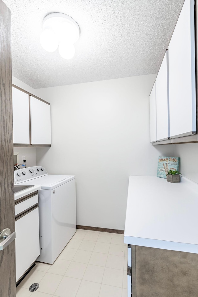 laundry room featuring cabinet space, baseboards, washer / clothes dryer, and a textured ceiling