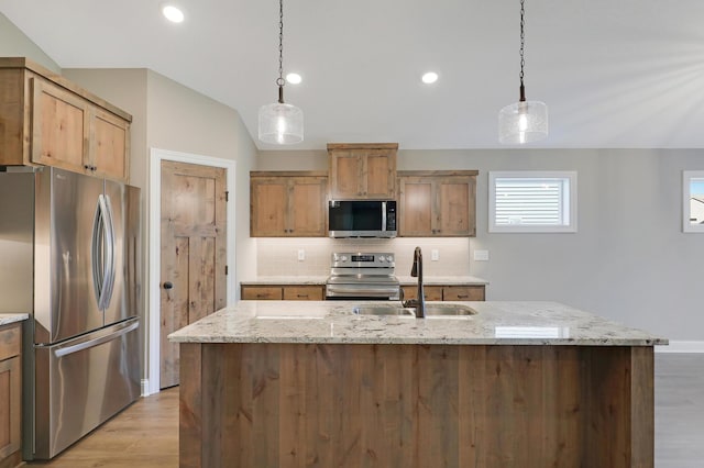 kitchen with stainless steel appliances, light stone countertops, hanging light fixtures, and sink