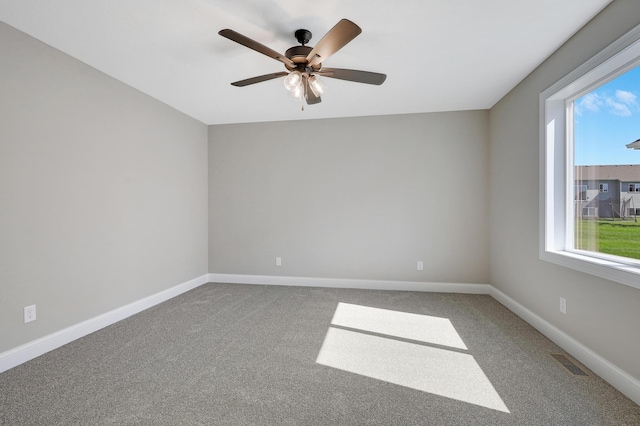 carpeted spare room featuring ceiling fan