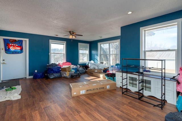 interior space with ceiling fan, dark hardwood / wood-style flooring, and a textured ceiling