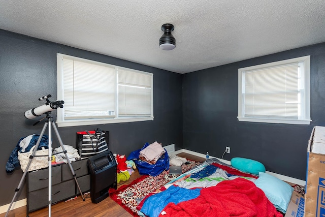 bedroom with wood-type flooring and a textured ceiling