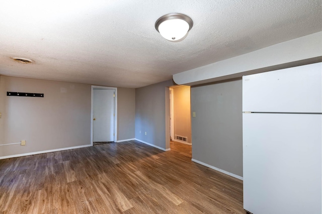 unfurnished room with dark hardwood / wood-style flooring and a textured ceiling