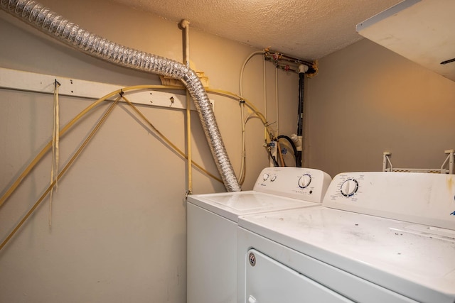 washroom with washer and dryer and a textured ceiling