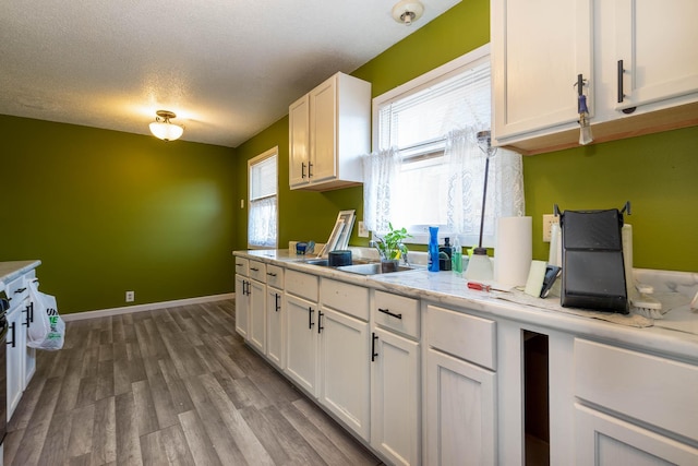 kitchen with white cabinetry, sink, plenty of natural light, and hardwood / wood-style floors