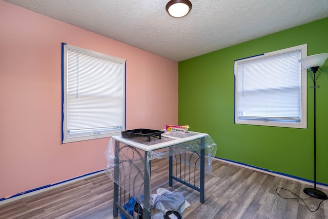 home office with a textured ceiling and light wood-type flooring